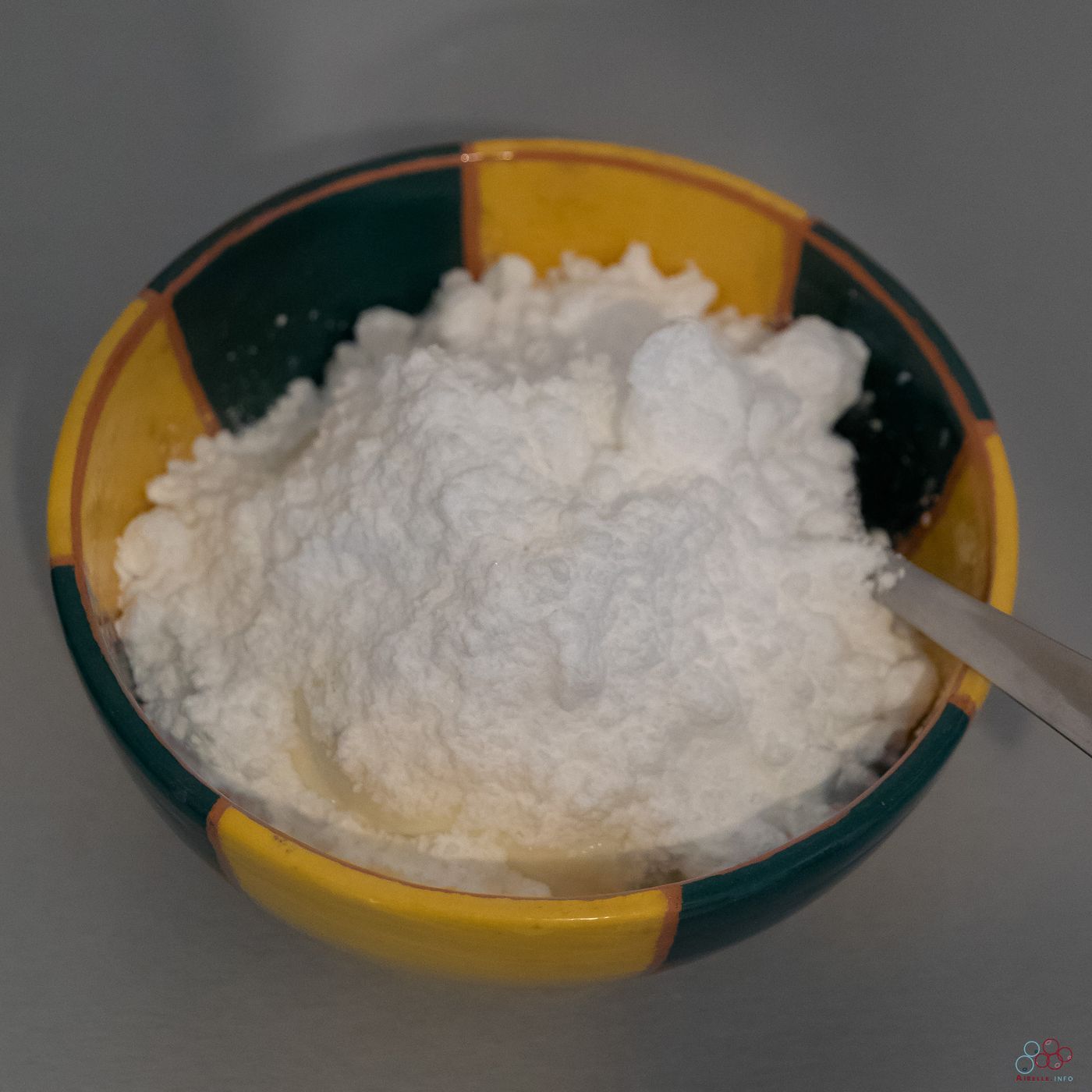 Photo of a bowl containing unmixed cottage cheese and icing sugar.